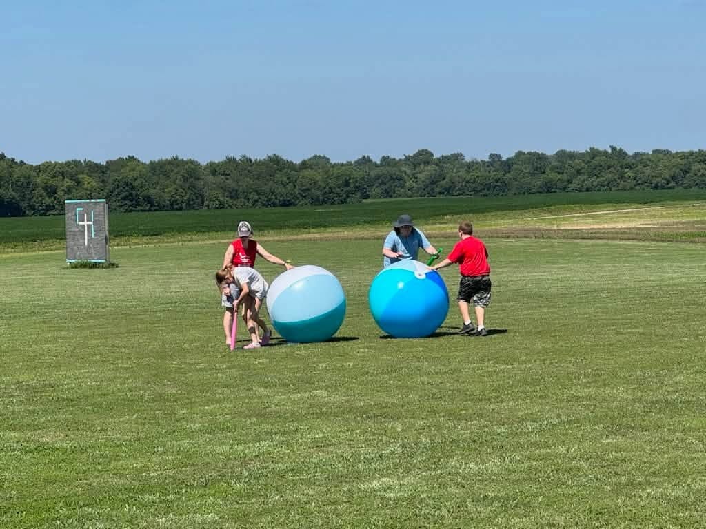 Campers playing with giant balls in a field
