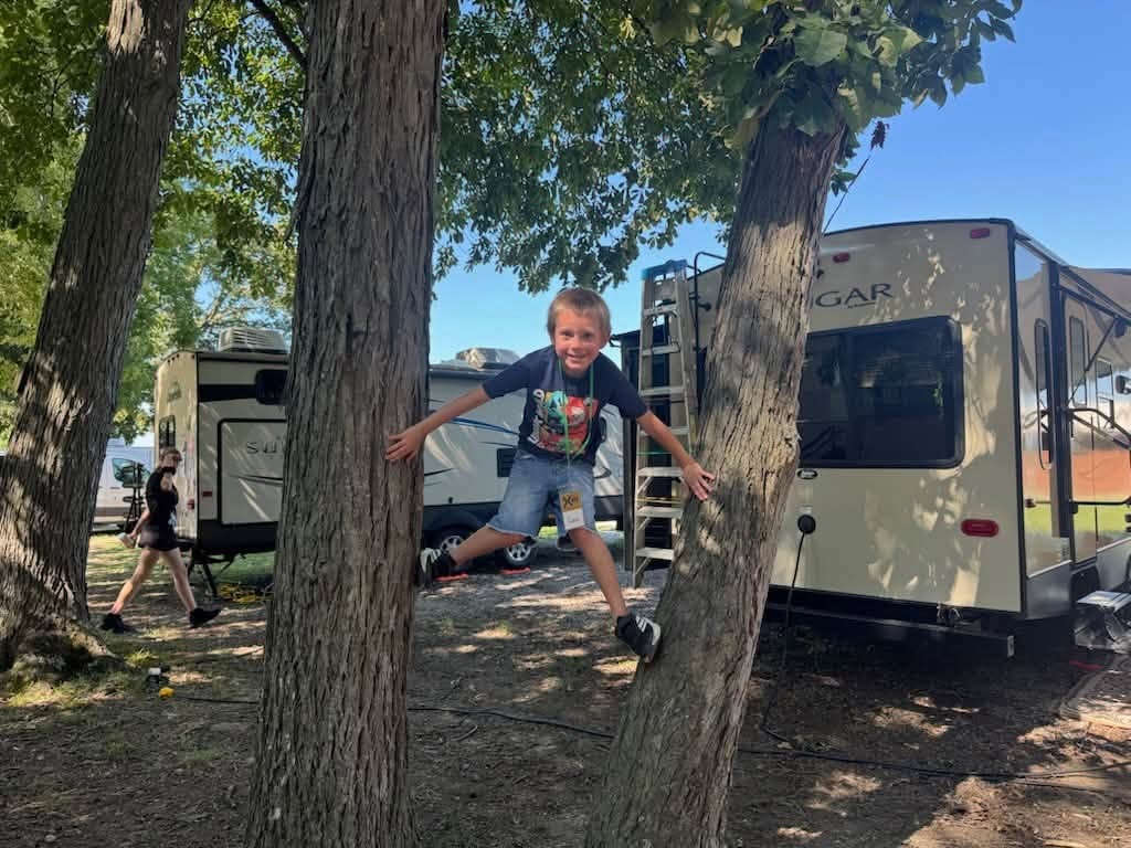 Young camper climbing a tree at camp