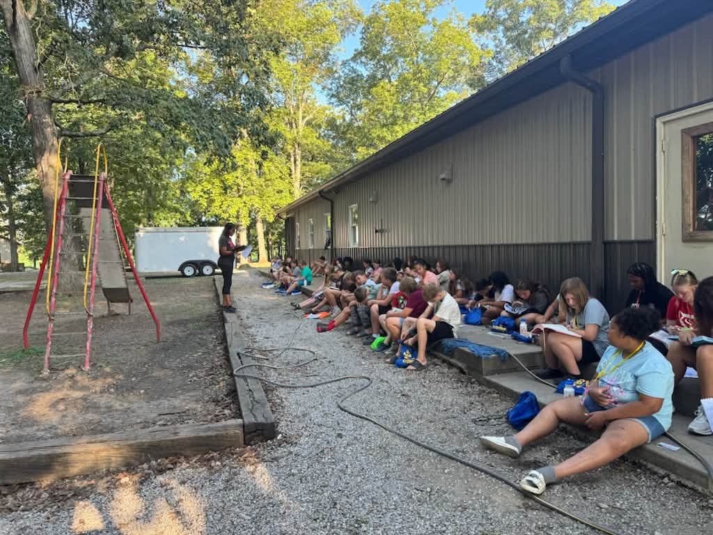 Campers laughing together at lunch tables