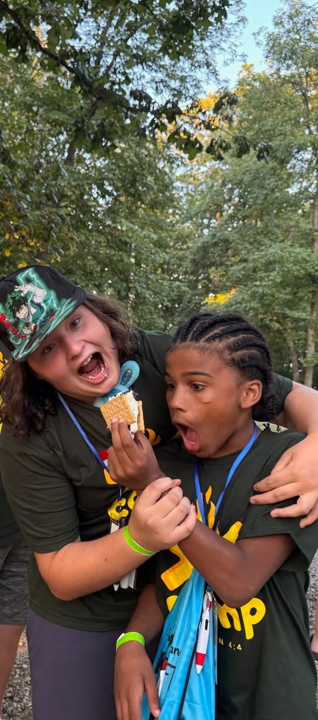 Campers laughing together with s'mores